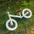 beige Køvapää loopfiets buiten in het gras gefotografeerd