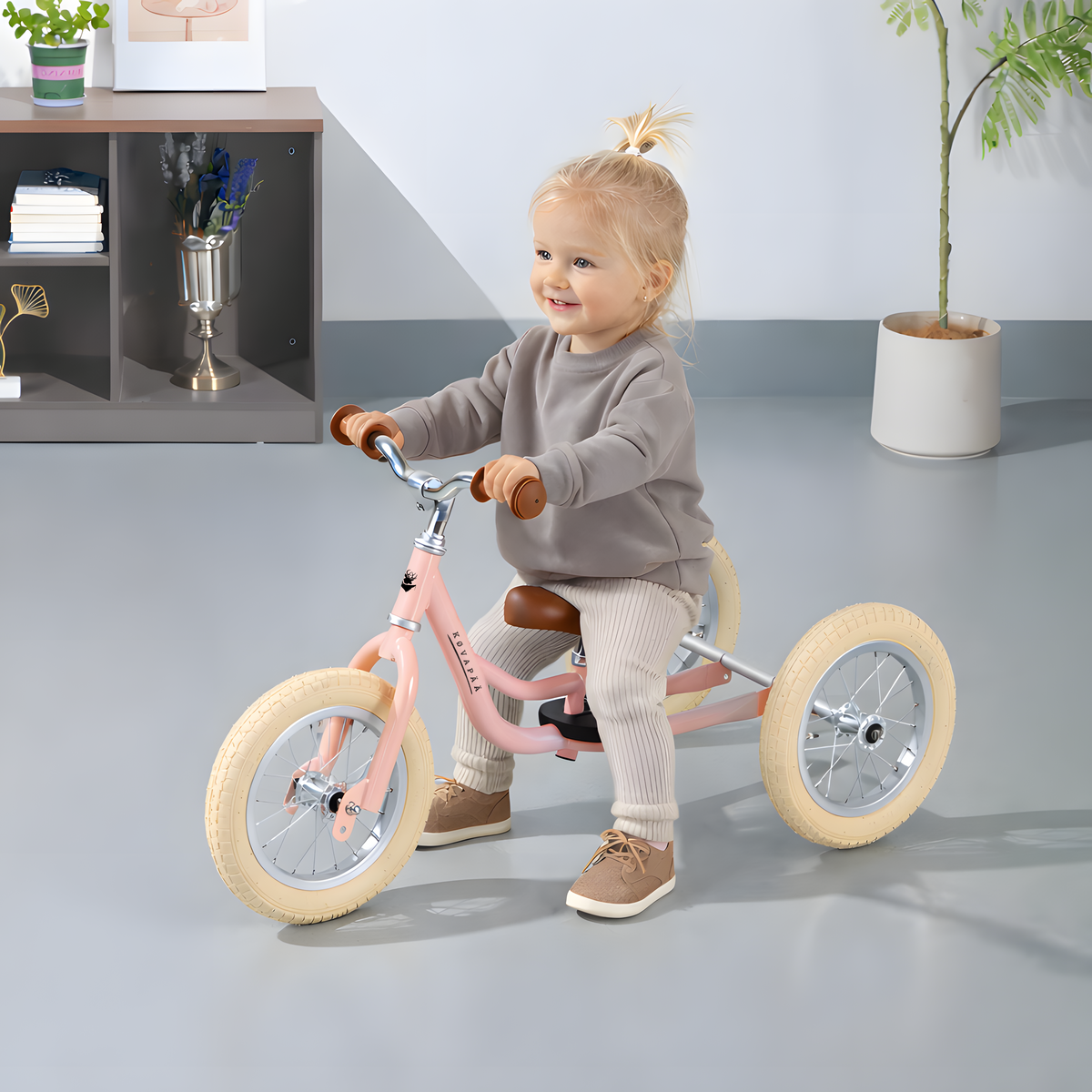 Kovapää 2 in 1 Loopfiets Roze - kind geniet van het rijden op een loopfiets in de woonkamer.
